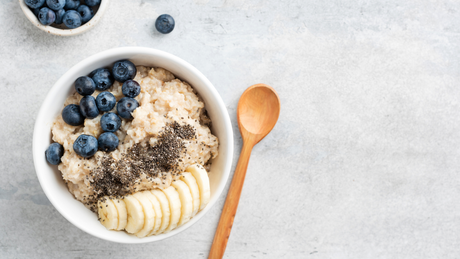 Porridge di avena con banana, mirtilli e semi di chia, esempio di snack proteico ed energetico per sportivi in autunno.
