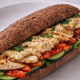 Alt text
Dettaglio di sandwich con baguette proteica ricca di fibre farcita con pollo grigliato, pomodori, cetrioli e hummus