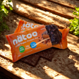 Barrette proteiche vegane Nätoo gusto Salted Caramel con cioccolato e caramello, foto ambientata con luce naturale